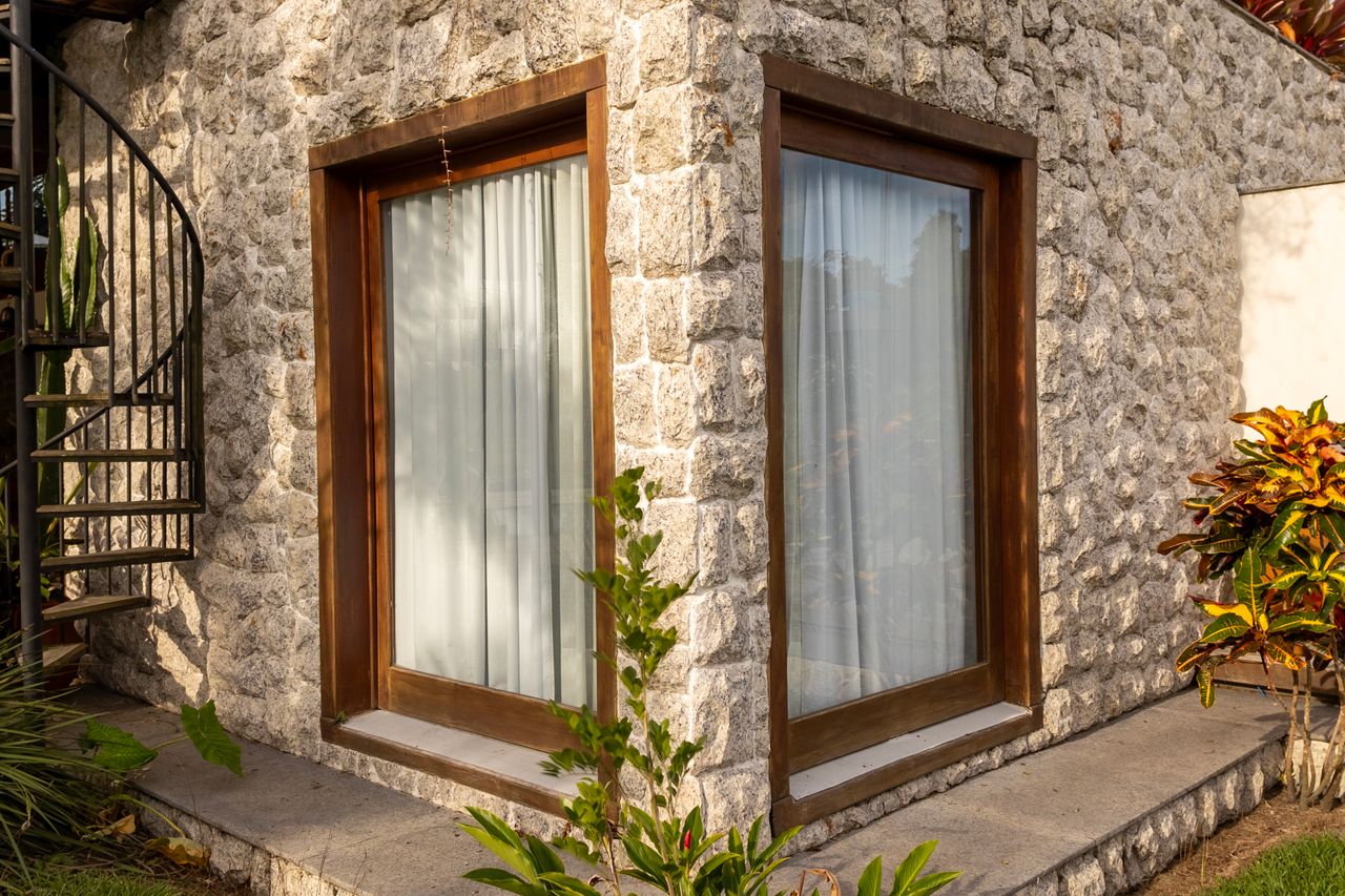Charming stone house corner with spiral stairs and plants in Itaúnas, Brazil.